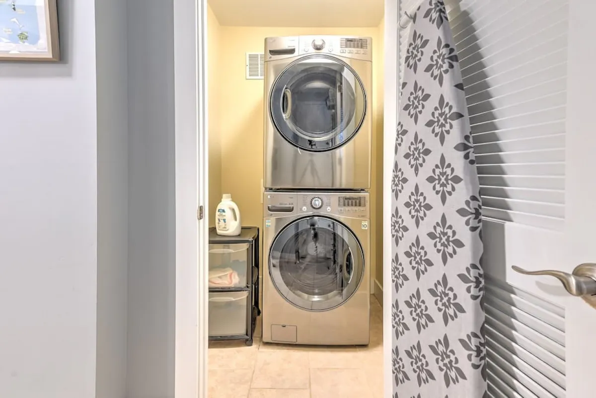 A practical laundry area with a washer and dryer, detergent bottle, and organized storage, providing guests with everything needed for convenient in-home laundry care.